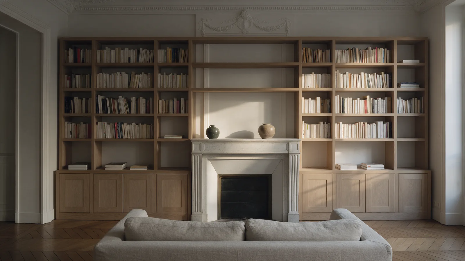 Bibliothèque sur mesure en chêne clair autour d'une cheminée en marbre blanc
